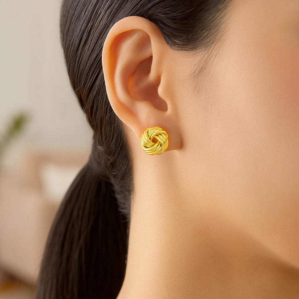 Polished Love Knot Stud Earrings in 14K Yellow Gold, worn