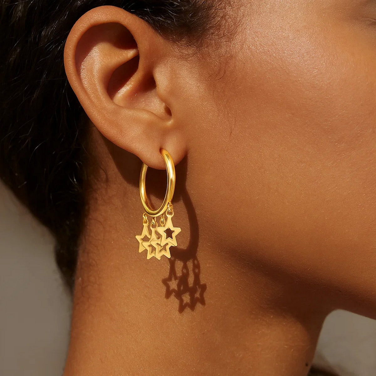 Star Charm Huggie Hoop Earrings in 14K Yellow Gold, worn